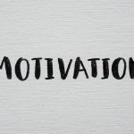Inspirational word 'Motivation' in black on a white textured canvas background.